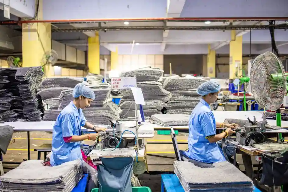 Workers operate machinery in a factory environment.