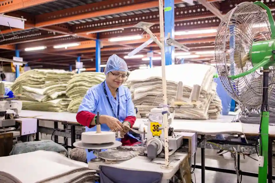 Woman working at a textile factory cutting fabric.